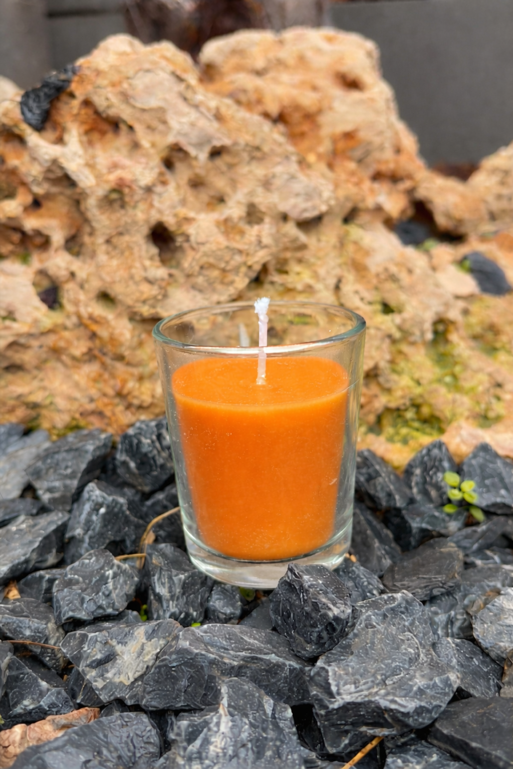 vela naranja sobre rocas oscuras